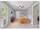 Cozy dining area features neutral walls, a ceiling fan, and a classic wooden table set near the patio entrance at 5672 W New York St, Indianapolis, IN 46224