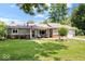 Charming single-story home features a well-manicured lawn, neutral siding, and cozy front porch at 5672 W New York St, Indianapolis, IN 46224