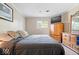 Relaxing main bedroom with warm, neutral walls, a large window, a bed with plush bedding, and a wooden dresser at 5672 W New York St, Indianapolis, IN 46224