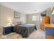 Comfortable main bedroom with neutral walls, a bed with plush bedding, and stylish matching wood furniture at 5672 W New York St, Indianapolis, IN 46224