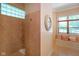 Bright bathroom with a stone-walled shower, window seat, and decorative pillows at 5720 Hickory Hollow Dr, Plainfield, IN 46168