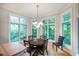 Cozy dining room with a round table, six chairs, and large windows showcasing a green landscape at 5720 Hickory Hollow Dr, Plainfield, IN 46168