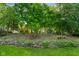 The home is surrounded by mature trees and a stone wall at 5720 Hickory Hollow Dr, Plainfield, IN 46168