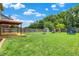 A well maintained back yard with a deck, a gazebo, a fire pit, a trampoline, and play set at 5841 Sable Dr, Indianapolis, IN 46221