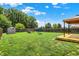 A well maintained back yard with a deck, a gazebo, a fire pit, a trampoline, and play set at 5841 Sable Dr, Indianapolis, IN 46221