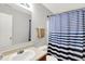 Bathroom features a large mirror, a sink, a toilet, and a shower with a blue and white striped curtain at 5841 Sable Dr, Indianapolis, IN 46221