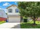 Charming two-story home featuring a two-car garage and well-maintained front yard with mature trees at 5841 Sable Dr, Indianapolis, IN 46221