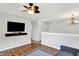 Upstairs living room features hardwood floors, ceiling fan, and mounted tv at 5841 Sable Dr, Indianapolis, IN 46221
