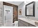Stylish bathroom featuring a wood-accent wall, modern vanity, and an adjacent laundry area at 5903 Birchwood Ave, Indianapolis, IN 46220