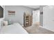 Cozy bedroom with neutral tones, carpeted floor, storage cabinet, and view to open doorway at 5903 Birchwood Ave, Indianapolis, IN 46220