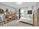 Bright bedroom with abstract wallpaper, large window, wood storage and a comfortable bed at 5903 Birchwood Ave, Indianapolis, IN 46220