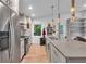 Bright kitchen with stainless appliances, gray cabinets, and bar seating overlooking the living area at 5903 Birchwood Ave, Indianapolis, IN 46220