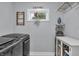 Functional laundry room with modern washer/dryer, storage, and window for natural light at 5903 Birchwood Ave, Indianapolis, IN 46220