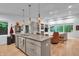 Open kitchen with stainless steel appliances, gray cabinets, leading into the bright living room at 5903 Birchwood Ave, Indianapolis, IN 46220