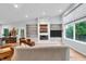 Spacious living room featuring modern fireplace, hardwood floors, and natural light from large windows at 5903 Birchwood Ave, Indianapolis, IN 46220