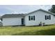 The rear exterior of this home features a well-maintained lawn and an access door at 6408 W Taylor Rd, Muncie, IN 47304