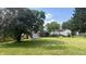 Spacious backyard features a well-maintained lawn, mature trees, and storage sheds at 6408 W Taylor Rd, Muncie, IN 47304