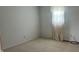 An empty bedroom with light carpet, light walls, and window with a curtain at 6408 W Taylor Rd, Muncie, IN 47304