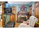 Finished basement with exercise equipment and a cozy fireplace setting at 6420 Colt Ln, Anderson, IN 46013