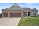 Charming single-story brick home featuring a well-manicured lawn and a three-car garage at 6420 Colt Ln, Anderson, IN 46013