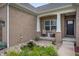 Inviting front porch with seating area and decorative pond surrounded by lush landscaping at 6420 Colt Ln, Anderson, IN 46013