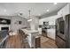 Modern kitchen featuring an island with barstool seating, stainless steel appliances, and gray backsplash at 6420 Colt Ln, Anderson, IN 46013