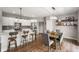 Well-lit kitchen with white cabinets, stainless steel appliances, island with bar seating, and adjacent dining area at 6420 Colt Ln, Anderson, IN 46013