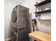 Convenient laundry area with stacked washer and dryer, wooden countertop, and floating shelves at 6420 Colt Ln, Anderson, IN 46013