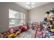 Cheerful playroom with carpet and an array of toys, including a play kitchen and toy storage units at 6420 Colt Ln, Anderson, IN 46013