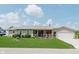 Charming single-story home with a manicured lawn and a cozy front porch decorated with patriotic decor at 6550 Reed Rd, Pittsboro, IN 46167