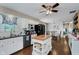 Bright kitchen features white cabinets, black appliances, and a central island with butcher block countertop, plus a dining area at 6550 Reed Rd, Pittsboro, IN 46167