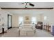 Comfortable bedroom featuring neutral walls, exposed beams, a ceiling fan, a sitting area, and carpet flooring at 6550 Reed Rd, Pittsboro, IN 46167