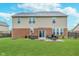 Home back exterior with a brick patio, outdoor seating and lush green lawn under a cloudy sky at 6589 Kara Ln, Brownsburg, IN 46112