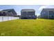 Rear view of the home, and a large grassy backyard is fully fenced at 7128 Verwood Ct, Plainfield, IN 46168