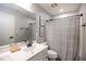 Well-lit bathroom featuring a single sink vanity with modern fixtures and a shower with a striped curtain at 7128 Verwood Ct, Plainfield, IN 46168