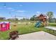 Spacious backyard featuring a playground set, playhouse, lake access, and a fire pit with seating at 757 Carson Ln, Greenfield, IN 46140