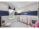 Bedroom with a cute rainbow-themed decor, including a crib, rocker, and view of the backyard pond at 757 Carson Ln, Greenfield, IN 46140