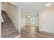 Bright entryway featuring wood-look floors, staircase, and a view to the living area through a large window at 8248 Ossian Ct, Camby, IN 46113