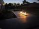 Enjoy outdoor evenings with a built-in fire table on the backyard patio near the pool at 8460 Ferguson Cir, Avon, IN 46123