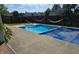 Backyard with a fenced-in pool, concrete patio, and lush greenery at 8460 Ferguson Cir, Avon, IN 46123