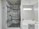 Beautiful bathroom featuring a walk-in shower with decorative stone floor and a soaking tub at 8557 Vyners Ln, Avon, IN 46123