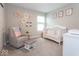 Cozy Bedroom featuring a crib, glider, and calming decor, creating a peaceful environment at 9309 Kellner St, Pendleton, IN 46064