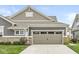A single-Gathering home with a two-car garage and brick facade surrounded by a plush green lawn at 10814 Matherly Way, Noblesville, IN 46060