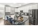 Modern kitchen featuring stainless steel appliances, a granite island with seating, and stylish backsplash details at 10814 Matherly Way, Noblesville, IN 46060