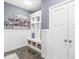 Mud room with custom built-ins, bench seating, storage baskets and decorative wall art at 10814 Matherly Way, Noblesville, IN 46060