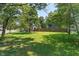 Expansive backyard showcasing a large, grassy area bordered by mature trees and a wooden fence at 11315 House St, Indianapolis, IN 46259