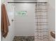 This bathroom has a shower with a pebble floor, and a neutral shower curtain and towel at 11315 House St, Indianapolis, IN 46259