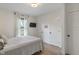 This bedroom has soft, natural light, and features a window with white curtains and a wall-mounted television at 11315 House St, Indianapolis, IN 46259