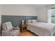 Relax in this cozy bedroom with an accent wall, a wood nightstand, a comfortable chair, and wood floors at 11315 House St, Indianapolis, IN 46259