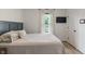 This bedroom has soft, natural light, and features a window with white curtains and a wall-mounted television at 11315 House St, Indianapolis, IN 46259
